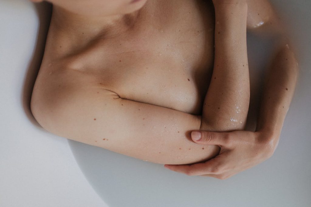pexels photo 9376352 A serene moment of a person relaxing topless in a bathtub, captured with soft lighting.